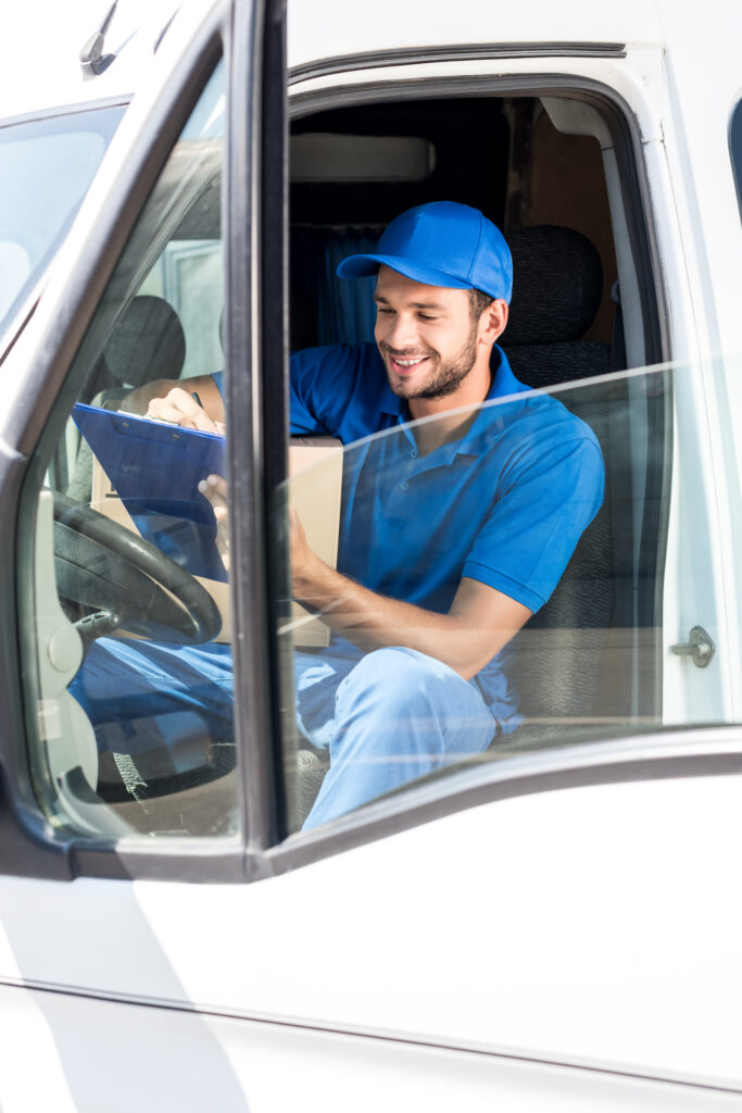 Mitarbeiter sitzt in einem Transporter und füllt eine Checkliste aus